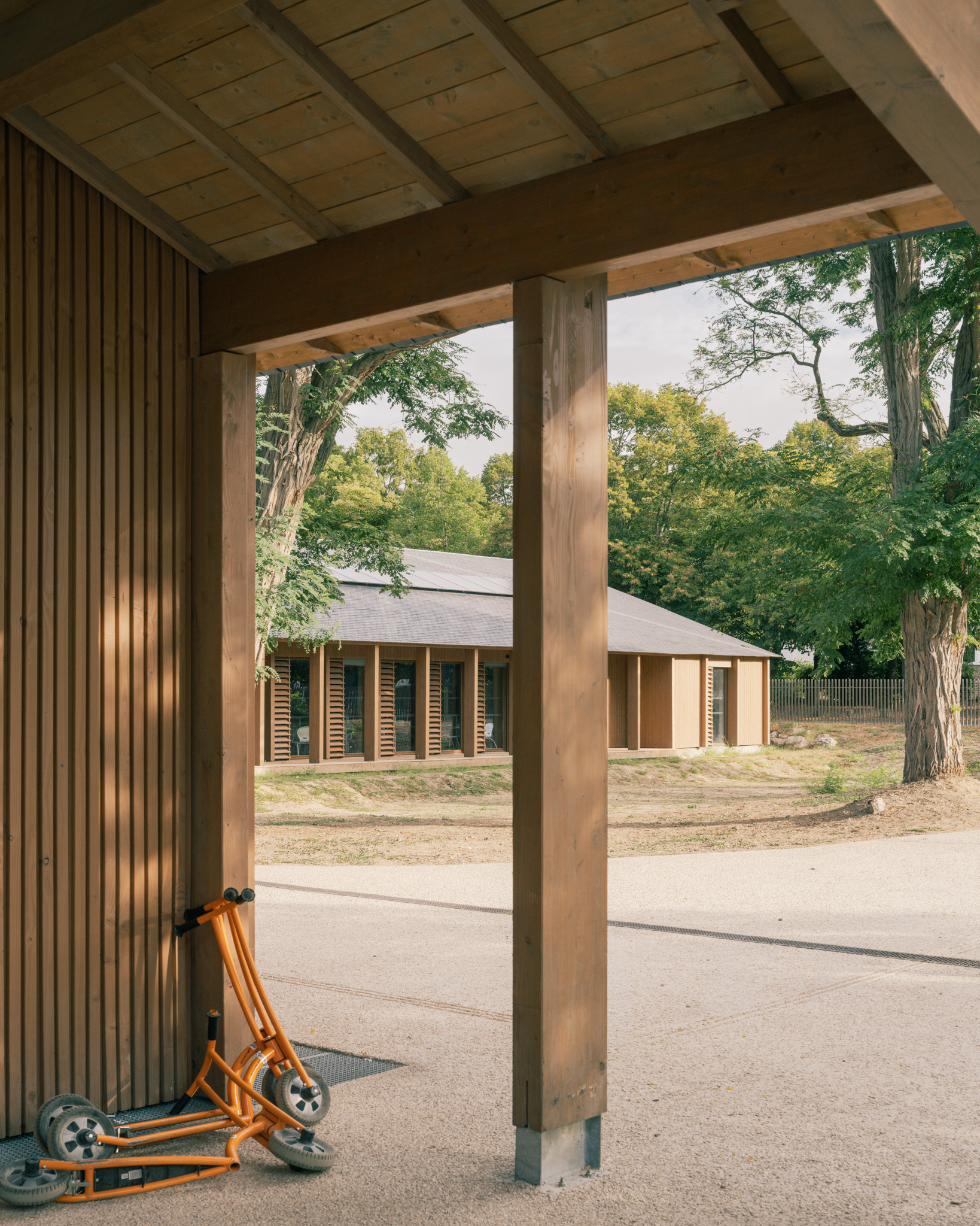 Reportage photographique du futur Centre de loisirs ALSH du Bois de Cergy, à Cergy (Val-d’Oise), conçu par PLURIEL[LES] ARCHITECTES pour la Ville de Cergy. Implanté sur une parcelle largement arborée située dans un Espace Boisé Classé, le projet accueille jusqu’à 200 enfants de 3 à 11 ans et développe une architecture en relation étroite avec son environnement naturel. Le bâtiment privilégie une construction bois et paille, avec bardage bois, charpente apparente, couverture en ardoise et toiture-terrasse végétalisée. Le projet intègre également des principes d’architecture bioclimatique et de production d’énergies renouvelables.