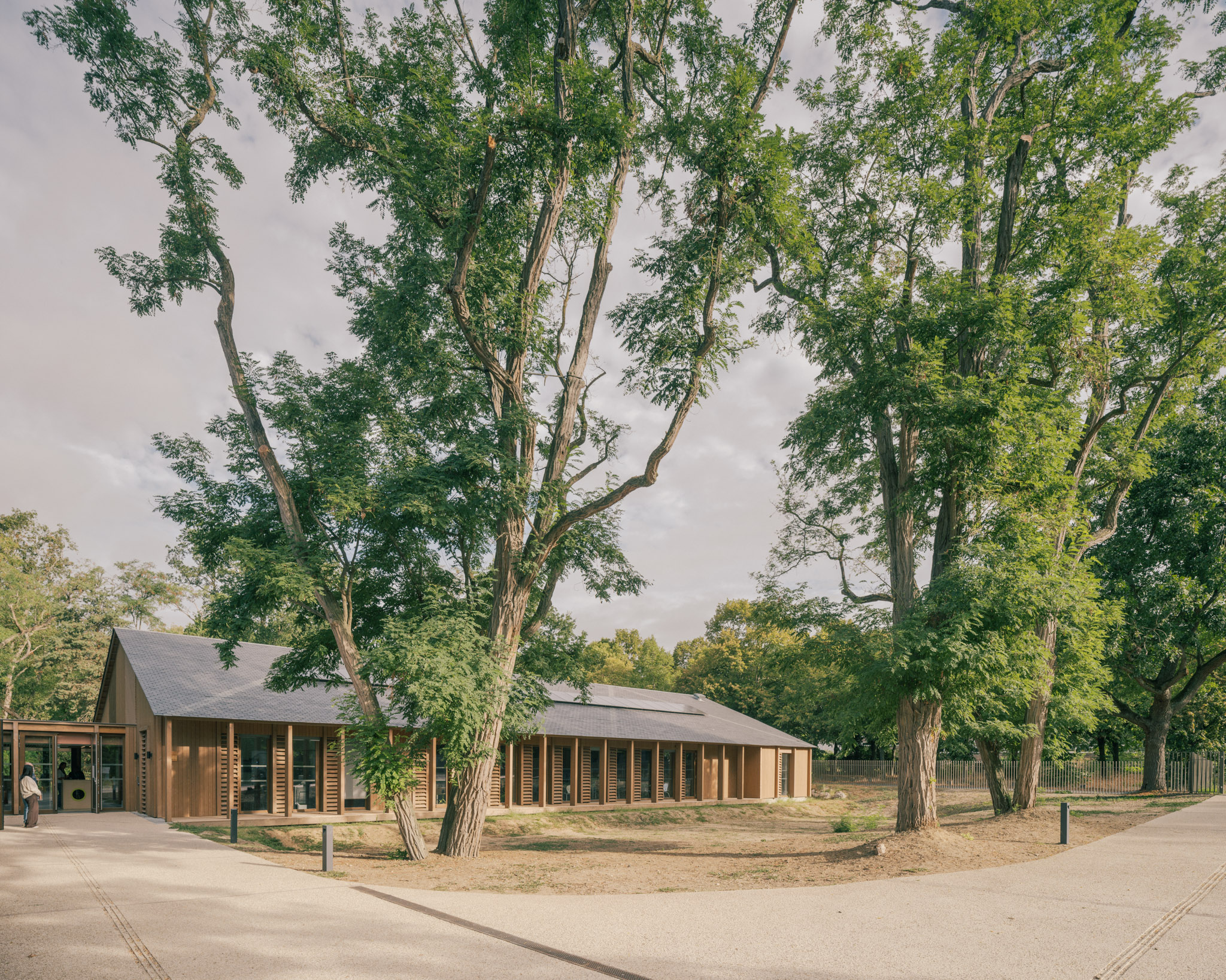 Reportage photographique du futur Centre de loisirs ALSH du Bois de Cergy, à Cergy (Val-d’Oise), conçu par PLURIEL[LES] ARCHITECTES pour la Ville de Cergy. Implanté sur une parcelle largement arborée située dans un Espace Boisé Classé, le projet accueille jusqu’à 200 enfants de 3 à 11 ans et développe une architecture en relation étroite avec son environnement naturel. Le bâtiment privilégie une construction bois et paille, avec bardage bois, charpente apparente, couverture en ardoise et toiture-terrasse végétalisée. Le projet intègre également des principes d’architecture bioclimatique et de production d’énergies renouvelables.